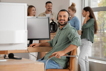 Male technical support agent working at table in office