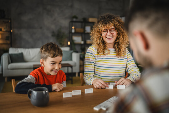 mom and son have quality time playing domino game together indoors