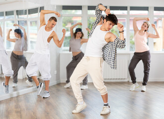 Group of young people perform choreographic exercises and teaches energetic mobile social dance waacking