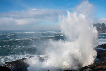 Water spout between rocks, waves crashing on rocky shores