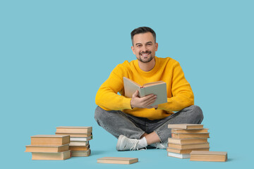 Handsome man reading book on blue background