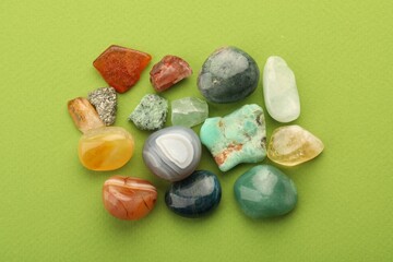 Beautiful natural gemstones on green background, flat lay