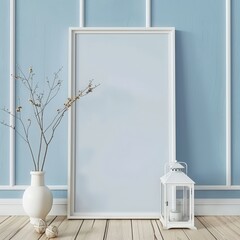 A white picture frame leaning against a light blue wall with a vase of dried branches. a lantern. and a decorative ball