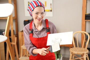 Female decorator with putty knives in room