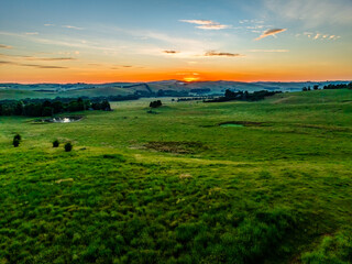 Sunrise over the countryside on the outskirts of country town with high cloud