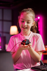 Child influencer filming wired mouse review in home studio, showing capabilities and...