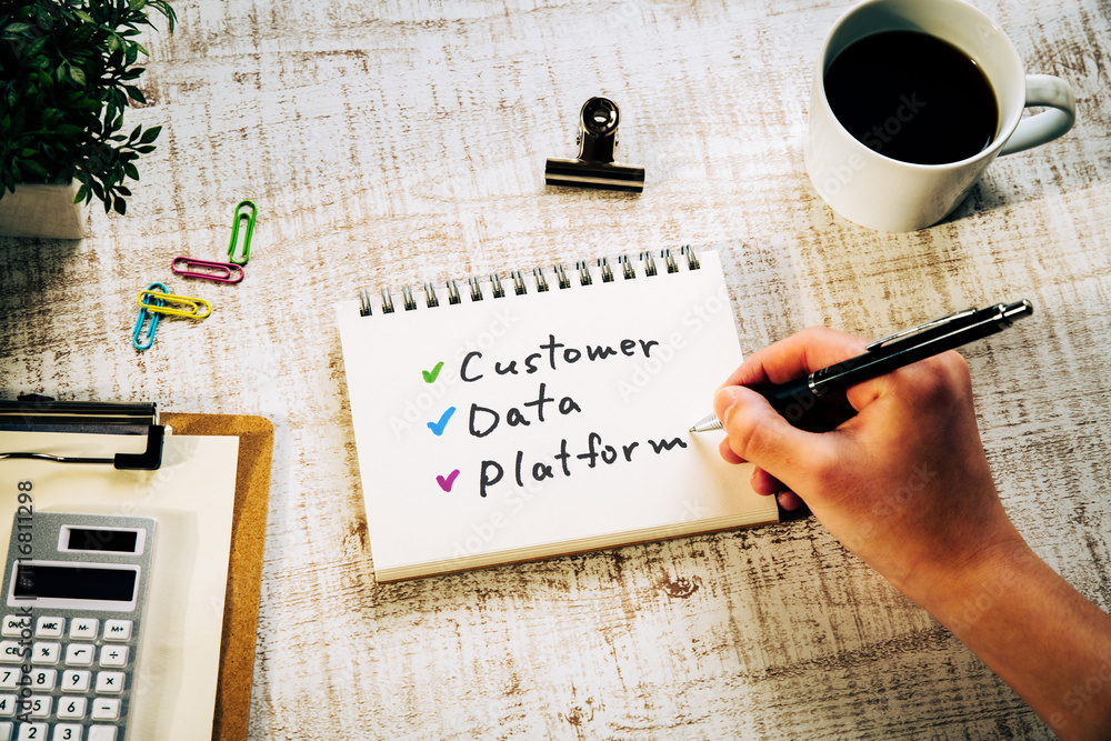 Poster there is notebook with the word customer data platform. it is as an eye-catching image.