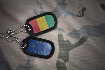 army blank, dog tag with national flag of guinea and european union on the khaki texture background. military concept.