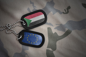 army blank, dog tag with national flag of sudan and european union on the khaki texture background....
