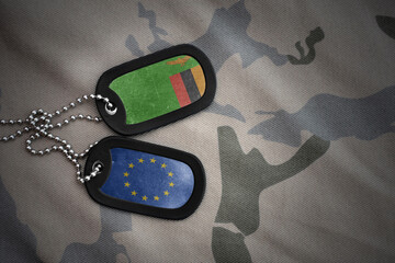 army blank, dog tag with national flag of zambia and european union on the khaki texture...