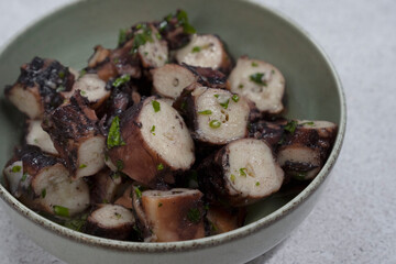 Seafood. Top view of cooked octopus with provencal sauce in a bowl