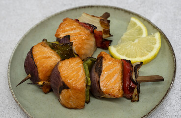 Delicious rustic food. Closeup view of a grilled salmon and vegetables brochette in a dish
