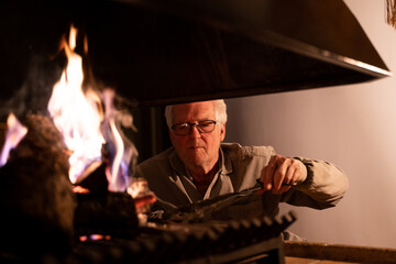 Senior Man Lighting Fireplace