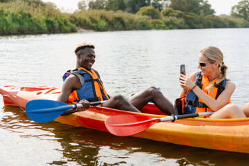 Friends take pictures in a canoe