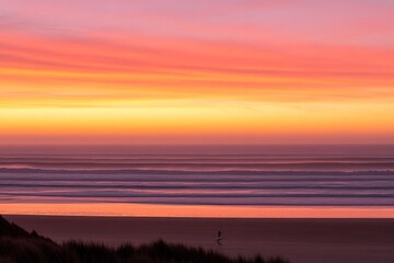 A serene beach at sunset with vibrant colors reflecting on the water.