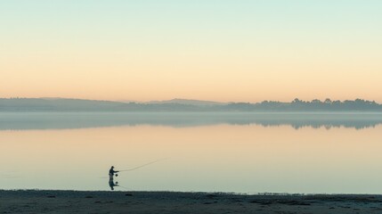 Fototapeta premium A serene early morning scene of a lone fisherman casting a line into a calm lake.