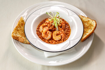A plate of shrimp and rice with a piece of toast on the side