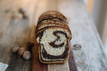 Sliced loaf of chocolate swirl bread on wooden board