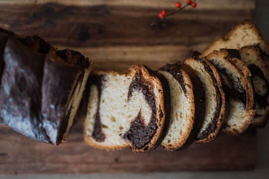 Sliced chocolate swirl bread on wooden board close-up.