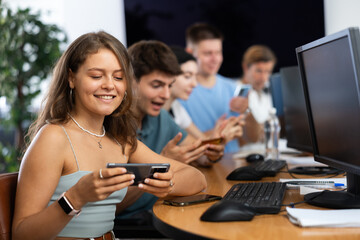 Student are engrossed in their mobile phones, working diligently on their tasks.
