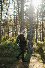 Naklejka premium Young caucasian man hiking or trekking through the forest 