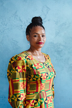 African woman in traditional patterned dress with a confident ex