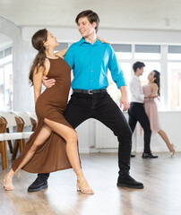 Energy young man paired girl and dancing samba in couple during lesson. Leisure activity. Two...