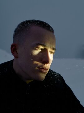 Young man thinks deeply in snowy twilight