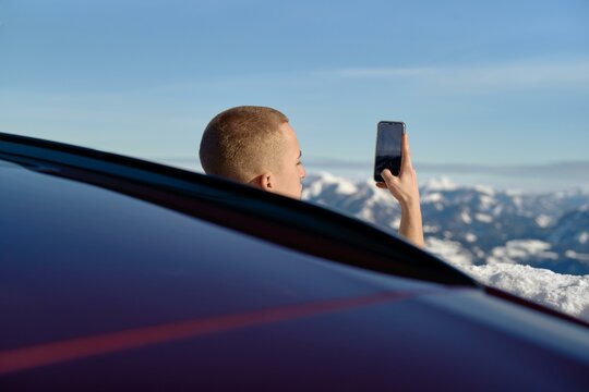 Capturing mountain memories from a snowy ledge