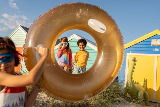 A funny shot of kids at the beach through a pool ring.