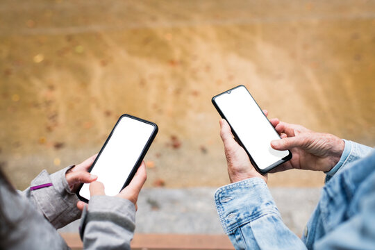 Mother and daughter with white screen mobile phones