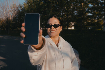 A woman points her phone screen at the camera