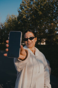 A woman points her phone screen at the camera