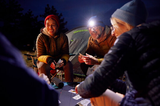 Friends have fun playing card games at the camp