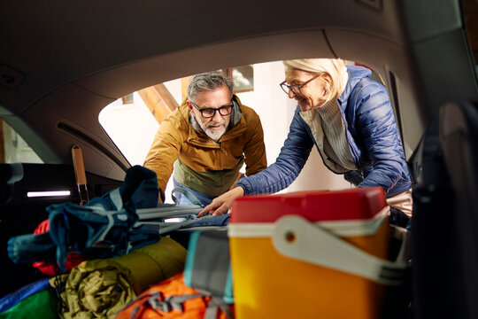Couple is loading the trunk, ready for their adventure