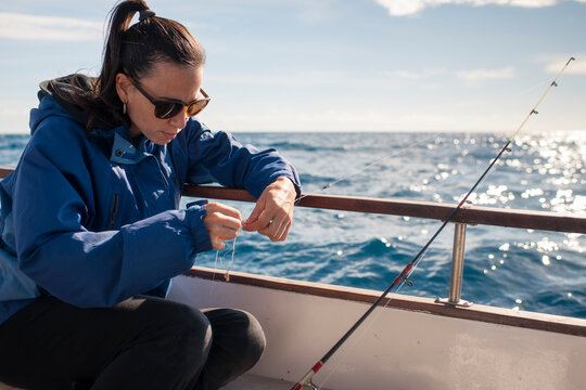 Woman getting ready for fishing on boat