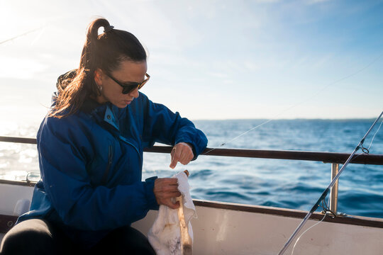 Focused woman fishing on boat
