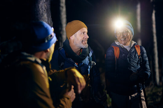 Group of friends chatting while hiking at night