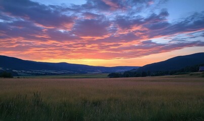 A serene sunset over a tranquil landscape with rolling hills and fields.