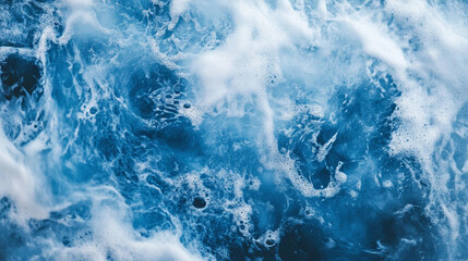 Obraz premium Churning ocean waves create foam and ripples under sunlight in coastal waters