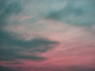 Fototapeta premium A moody, dramatic sky with dark clouds and a soft pink hue. Perfect for backgrounds or to evoke a sense of mystery and emotion
