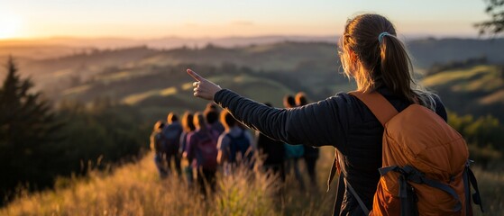 Woman leads hiking group at sunset, pointing to scenic vista.