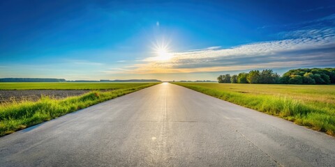 Side view of concrete road running through a peaceful meadow under a clear blue sky, concrete road, side view, meadow