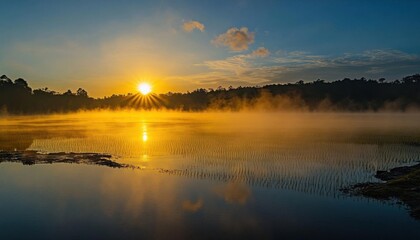 Obraz premium Serene sunrise over a misty lake, reflecting nature's beauty.