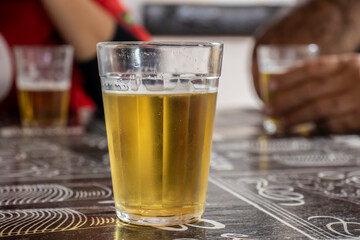 glass full of beer and foam on a bar table in Brazil. Typical Brazilian after-work meal with beer....