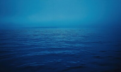 Obraz premium A serene ocean scene captured in deep blue hues and misty ambiance.