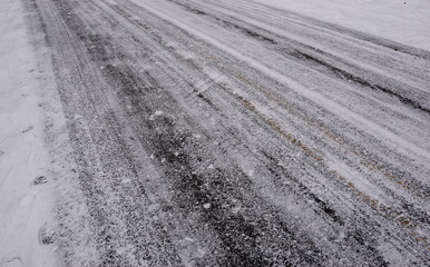 Tracks of car tires in thin layer of first snow 