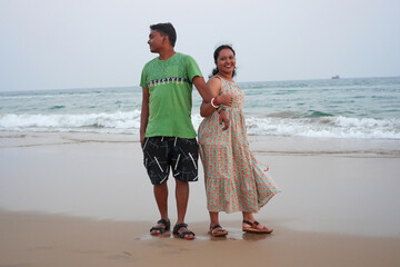 Wife reconcile her touchy husband and hugging couple in love at sea beach. Indian couple in love. Positive attitude, emotions concept.