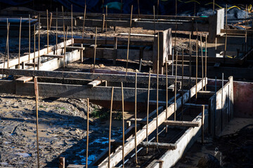 Residential construction start, foundation dug and cement pour forms started with wood and rebar, wet and buddy job site on a sunny winter day
