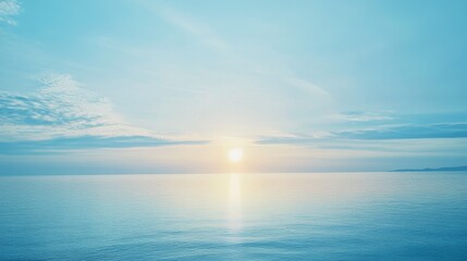 Obraz premium A serene ocean sunrise with soft blue tones.